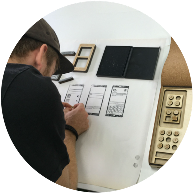 designer using a drawing board to wireframe mobile app screens by hand